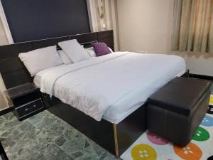 ein Schlafzimmer mit einem großen Bett mit weißer Bettwäsche in der Unterkunft Super Deluxe Room #1 in Ikeja + 24 Fotos