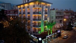 a tall white building with neon lights on it at Cleopatra City Hotel Alanya in Alanya