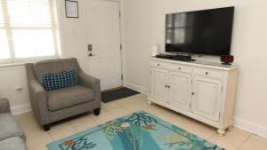 a living room with a television and a chair at Condo At The Cove Unit 5 in Cape May