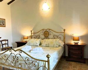 a bedroom with a large bed with white sheets and pillows at Historic Farmhouse In Maremma Countryside in Poggio Murella