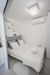 um quarto branco com uma cama com um lustre em Luxury Studio Apartment White Sensation em Vodice