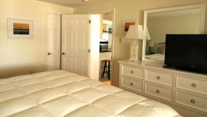 a bedroom with a bed and a flat screen tv at Condo At The Cove Unit 5 in Cape May