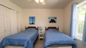 two beds in a bedroom with blue covers at 149 Emerald Avenue in West Cape May