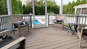 Una terraza con sillas y una mesa y una piscina. en Coastal Sanctuary, en West Cape May