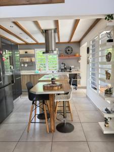 a kitchen with a wooden table and a dining room at Villa du FORT in Goyave