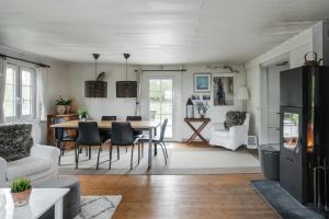 a dining room and living room with a table and chairs at Swedish Cottage By Forest And Lake In Småland in Traryd