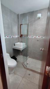 a bathroom with a toilet and a glass shower at The Hannah's house 2 in Cusco +18 photos