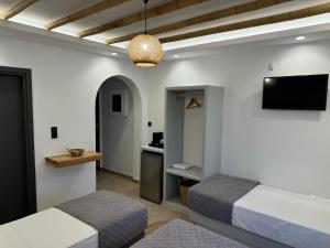 una camera da letto con due letti e una TV a parete di Olive Garden Hotel ad Agios Prokopios