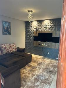 a living room with a couch and a flat screen tv at LUZ DO LUAR in Pedra Azul