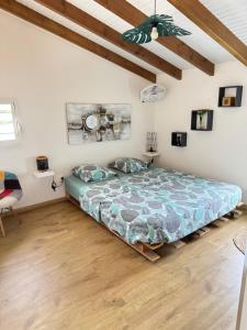 a bedroom with a bed in a room with wooden floors at Villa du FORT in Goyave +7 photos