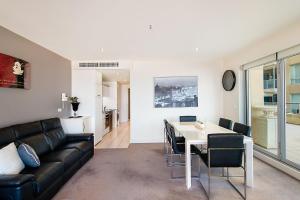 a living room with a couch and a table at Belle Escapes - Oceanfront Luxe at The Pier in Glenelg