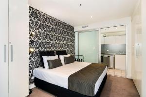 a bedroom with a bed and a black and white wall at Belle Escapes - Oceanfront Luxe at The Pier in Glenelg +25 photos