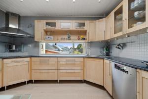 特罗姆瑟Large apartment for max 13pax Tromsø的带木柜和窗户的厨房