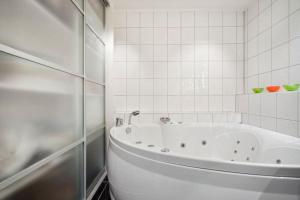 特罗姆瑟Large apartment for max 13pax Tromsø的白色瓷砖浴室内的白色浴缸 更多12张照片