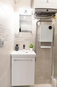 a bathroom with a white sink and a mirror at Appartement cosy A Paris RER B in Gentilly