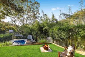 a backyard with a fire pit and a pool at Cottage on Riv - Winter Holiday Mid-Week Special in Terrigal