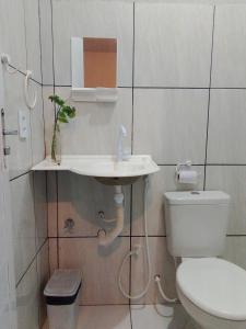 a white bathroom with a toilet and a sink at Aratu Pousada in Camocim +18 photos