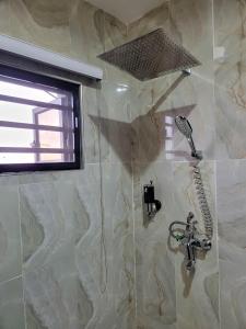 a bathroom with a shower with a hair dryer at Caesar's Hotel & Apartment Room #10 in Ikeja