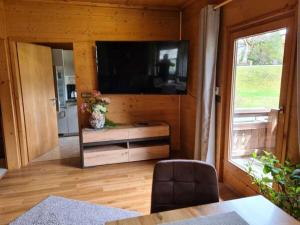 措布伦Cabin in Zöblen with swimming pool的客厅墙上有一台平板电视 更多14张照片