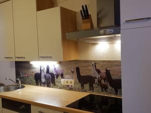 a kitchen with a painting of llamas and horses on the counter at Forest hyacinth riding stable Alpin Appart in Umhausen