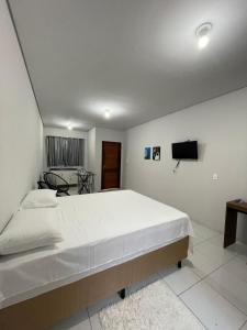 a bedroom with a large bed and a television at Apto com entrada individual 05 in Sinop
