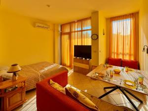 Habitación con cama y sala de estar con mesa. en Prime Location Studio Midia Beach, en Sunny Beach