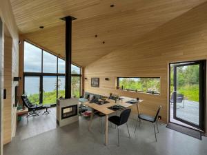 a room with a table and chairs and windows at Architect-Designed Cabin With View In Molde in Røvik