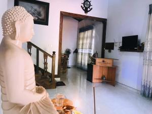 Una statua di una donna seduta in un soggiorno di The European Gate - Anuradhapura a Anuradhapura