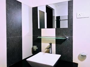bagno con servizi igienici bianchi e specchio di The European Gate - Anuradhapura a Anuradhapura