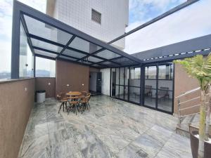a patio with a table and chairs and windows at LK Estoril 2 in Belo Horizonte