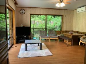 a living room with a table in the middle of it at Monet House モネハウス in Shimo-horado