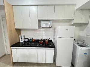 a white kitchen with a stove and a refrigerator at LK Centro 9 in Belo Horizonte