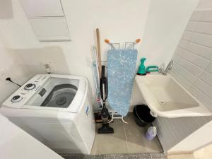 un baño con lavadora junto a un lavabo en LK Centro 9, en Belo Horizonte