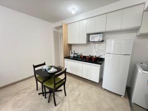 a small kitchen with a table and a white refrigerator at LK Centro 9 in Belo Horizonte