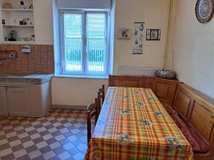 a kitchen with a table with a checkered floor at House near Lac de Madine with Historic Charm in Lahayville