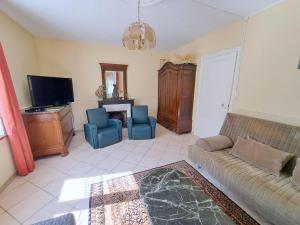 a living room with a couch and a tv at House near Lac de Madine with Historic Charm in Lahayville