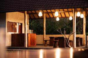 a restaurant with a table and chairs and lights at Kacu Bali Munduk in Munduk