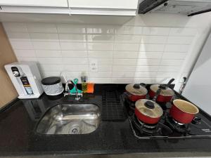 a kitchen counter with a stove with pots and pans at LK Centro 8 in Belo Horizonte +20 photos