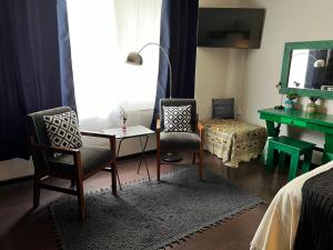 1 Schlafzimmer mit 2 Stühlen, einem Tisch und einem Spiegel in der Unterkunft Casa YOKO in Oaxaca de Juárez