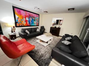 ein Wohnzimmer mit einem schwarzen Sofa und einem roten Stuhl in der Unterkunft Casa YOKO in Oaxaca de Juárez + 11 Fotos