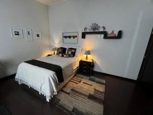 ein Schlafzimmer mit einem Bett und zwei Nachttischen mit Lampen in der Unterkunft Casa YOKO in Oaxaca de Juárez