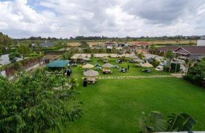 Esiankiki Resort & Spa - Nanyuki في نانيوكي: صورة جوية لحديقة بها طاولات ومظلات