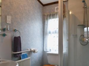 a bathroom with a sink and a toilet and a window at Rosella in Bridekirk +3 photos