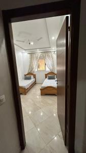 a room with two beds and a door to a bedroom at your home in Oued Laou