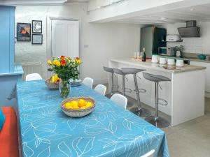 a kitchen with a blue table with fruit on it at Greycott - Uk48746 in Crantock