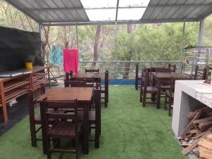a restaurant with tables and chairs on the grass at Hospedaje TUTUMEME in Churín