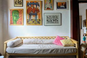 a wooden couch in a room with pictures on the wall at Conforto no Centro de Pirenópolis in Pirenópolis +36 photos
