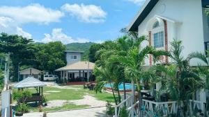 a house with palm trees next to a pool at Beachfront Mansion and Seascape Villas Calatagan with Outdoor Pool in Calatagan