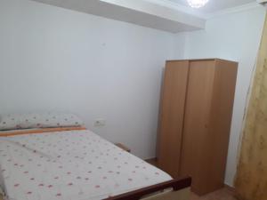 a bedroom with a bed and a wooden cabinet at Apartamento Turístico Céntrico Galper in Melilla