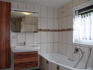 un baño con lavabo y bañera en Uns Oellernhuus, en Ostseebad Karlshagen 5 fotos más